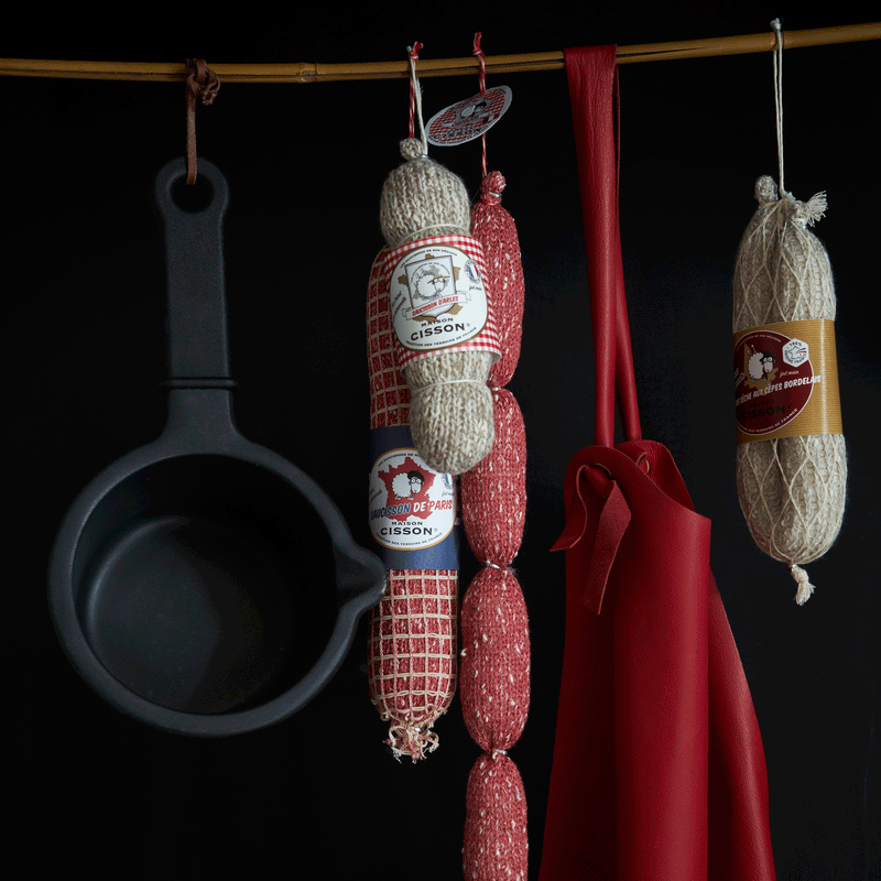 黒い鍋と赤いエプロンとメゾンシソンのニットサラミ